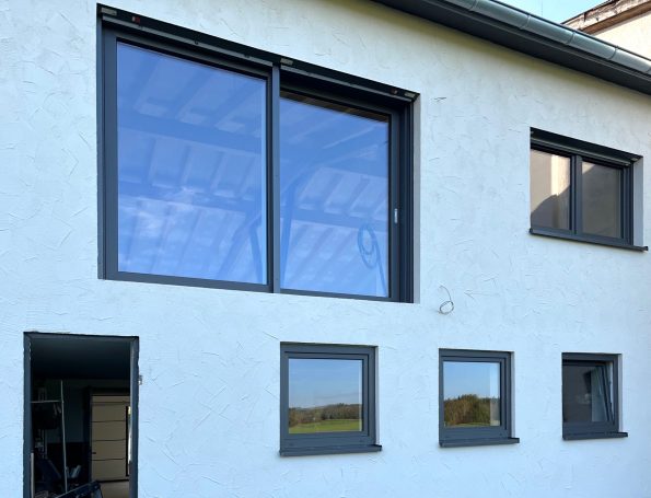 Moderne Fenster in einer hellen Fassade, mit Blick auf den Himmel und die Umgebung.