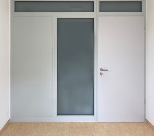 Weiße Tür mit Glasfenster in einem modernen Raum.