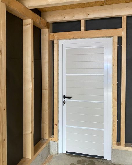 Weiße Innentür in einem Holzrahmen, umgeben von unvollendeten Wänden.