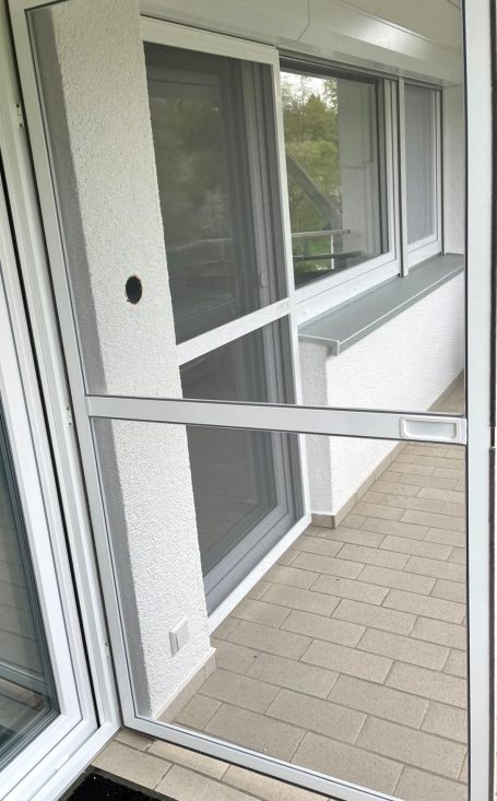 Weiße Fliegengittertür geöffnet